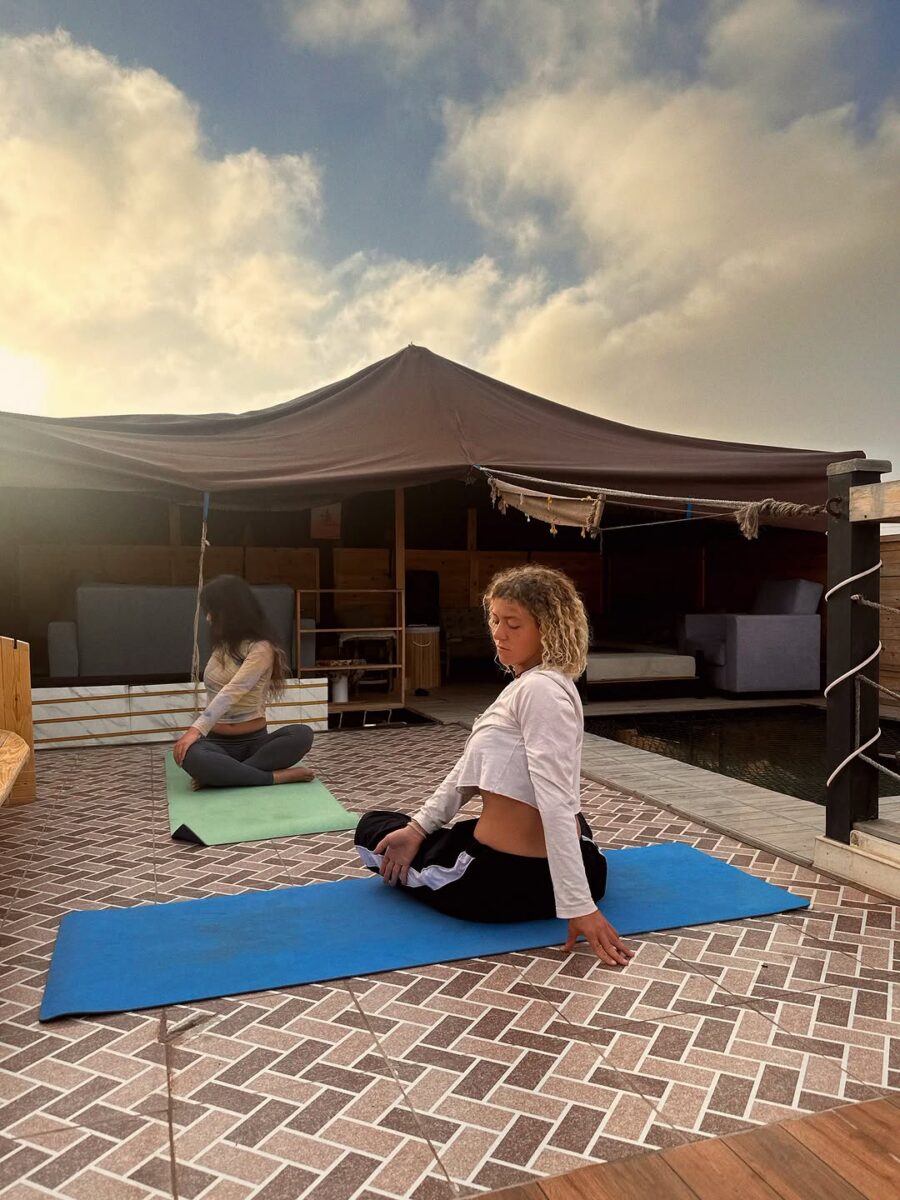 Travellers stretching on yoga mats on the rooftop