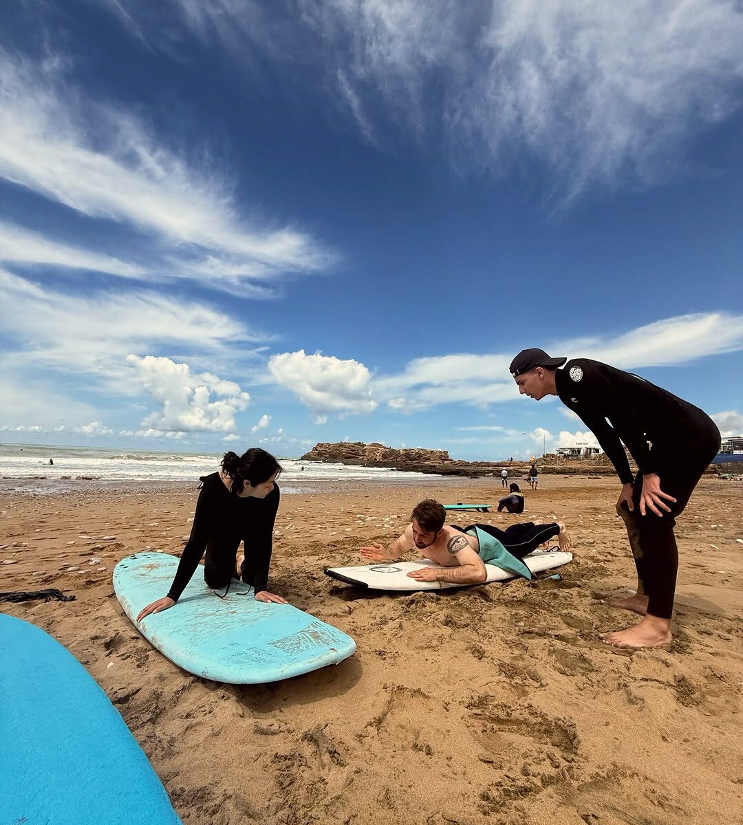 Travellers learning to surf on the beach