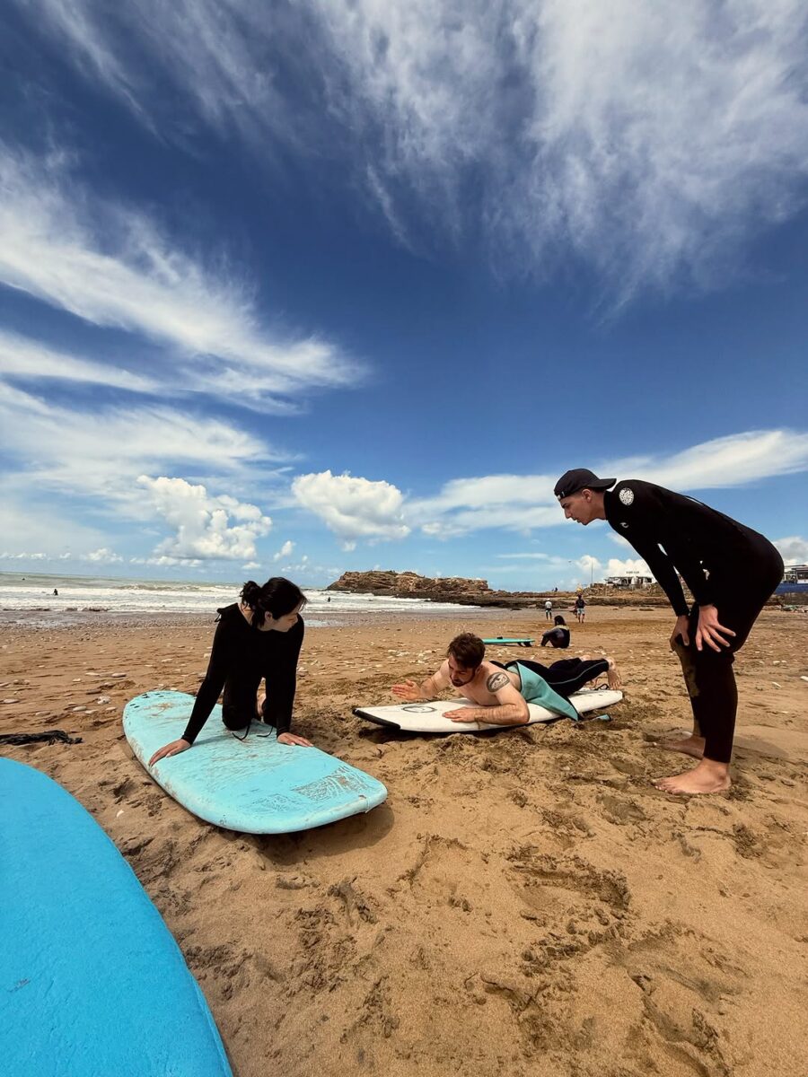 Travellers learning to surf on the beach