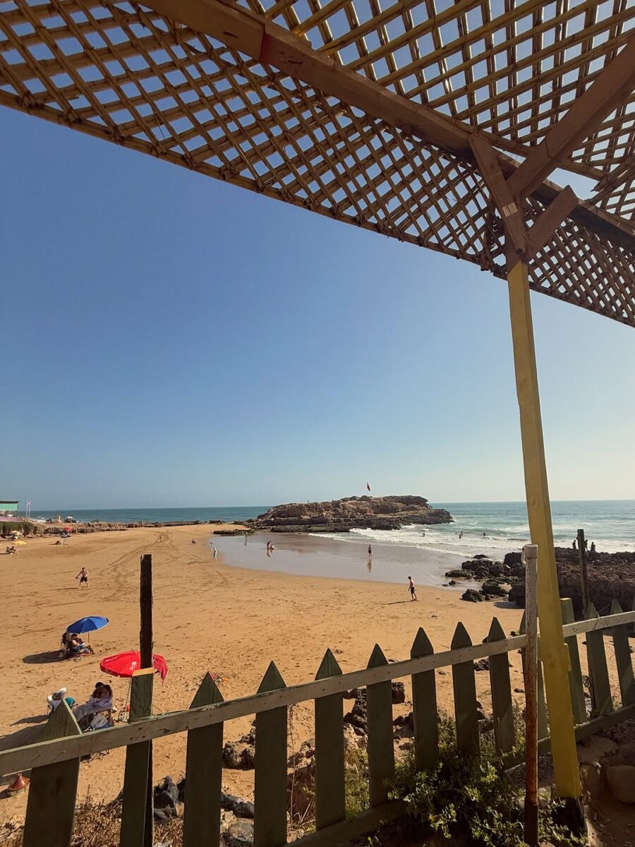A shaded terrace looking over a sandy beach