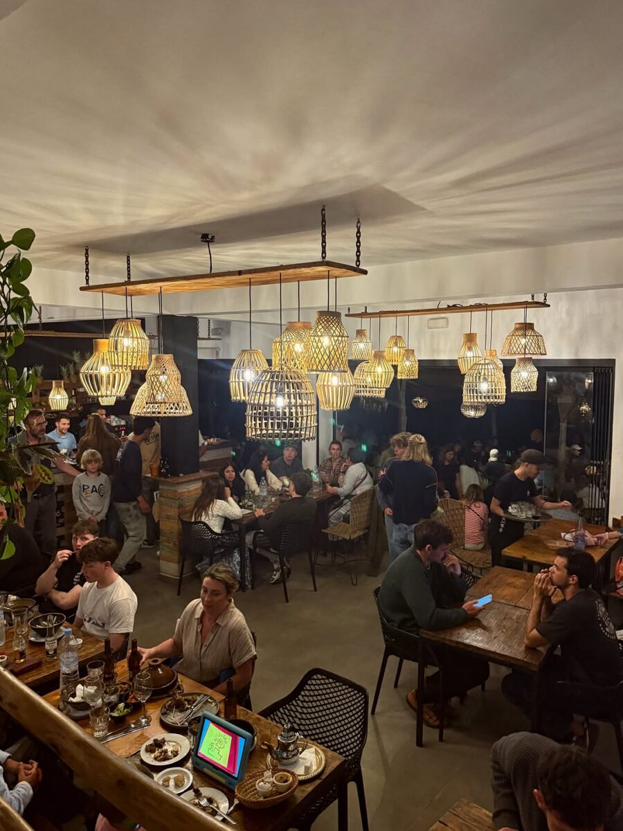 People gathering around tables in a warmly lit evening venue